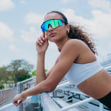 Woman athlete wearing LosReyes Prime Polarized Green wraparound sports sunglasses with polarized lenses during track training, showing lightweight comfort and full-face coverage for running, cycling, and high-mobility workouts