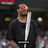 NFL player Ja'Marr Chase wearing LosReyes polarized red sports sunglasses with mirrored lenses during a baseball event, smiling and holding a water bottle, showcasing high-performance athletic eyewear.
