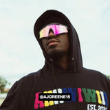 Lifestyle photo of AJ Greene wearing LosReyes iridescent mirrored shield sunglasses styled with a black hoodie, combining high-performance athletic eyewear with streetwear fashion and urban edge