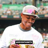 Lifestyle shot of Devonta Smith wearing LosReyes pink wraparound sports sunglasses featuring mirrored shield lenses, athletic frame design, and UV400 protection — perfect for performance and celebrity street style.