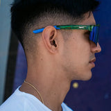 Lifestyle side profile of LosReyes Prime Galaxy Earth mirrored athletic sunglasses with green-blue lens and curved fit, ideal for baseball, training, and everyday active wear.