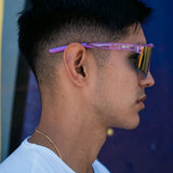 Profile lifestyle shot of LosReyes Prime Galaxy Mercury sports sunglasses, showing off the orange mirrored lens and translucent purple arms, built for performance and eye-catching urban style.