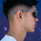 Side profile of LosReyes Prime Galaxy Moon sunglasses on model, displaying translucent arms, contoured shield lens, and space-grade performance aesthetic.