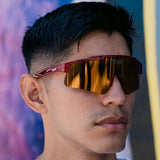 Lifestyle image of athlete wearing LosReyes Prime Galaxy Pluto red mirrored wraparound sunglasses, perfect for sun-intensive performance and street style.