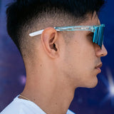 Side lifestyle shot of LosReyes Prime Galaxy Uranus sunglasses worn by athlete, showing streamlined arms, space-age blue mirrored lens, and futuristic clear frame detailing.