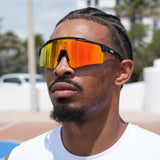 Side angle of athletic basketball player wearing orange polarized sunglasses by LosReyes – sport-specific shades for sunny courts