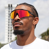 Game-ready basketball player sporting red reflective LosReyes Prime Polarized sunglasses – bold wraparound sports shades built for peak intensity and visual dominance
