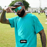 Odell Beckham Jr. wearing LosReyes Uranus Galaxy sunglasses and a turquoise shirt while posing at a football camp