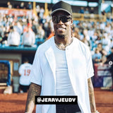 Jerry Jeudy smiling at a baseball game wearing a white jersey, black cap, and LosReyes polarized black sports sunglasses.