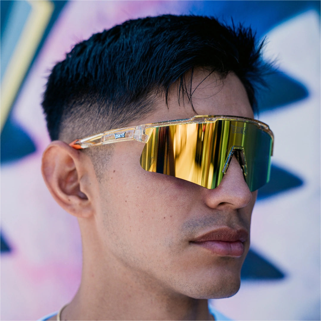 Front lifestyle view of LosReyes Prime Galaxy Sun wraparound yellow sports sunglasses with gold mirrored lens and amber speckled frame, modeled outdoors for versatile athletic use in sunlight.