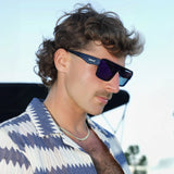 The LosReyes Poseidon sunglasses showcased in a clean, ocean-inspired lifestyle portrait. Deep-blue polarized lenses and sleek frame design built for clarity and style.
