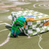 Pterodactyl youth sunglasses with UV400 protection and rubber tips displayed beside a checkered lunch bag during outdoor playtime.
