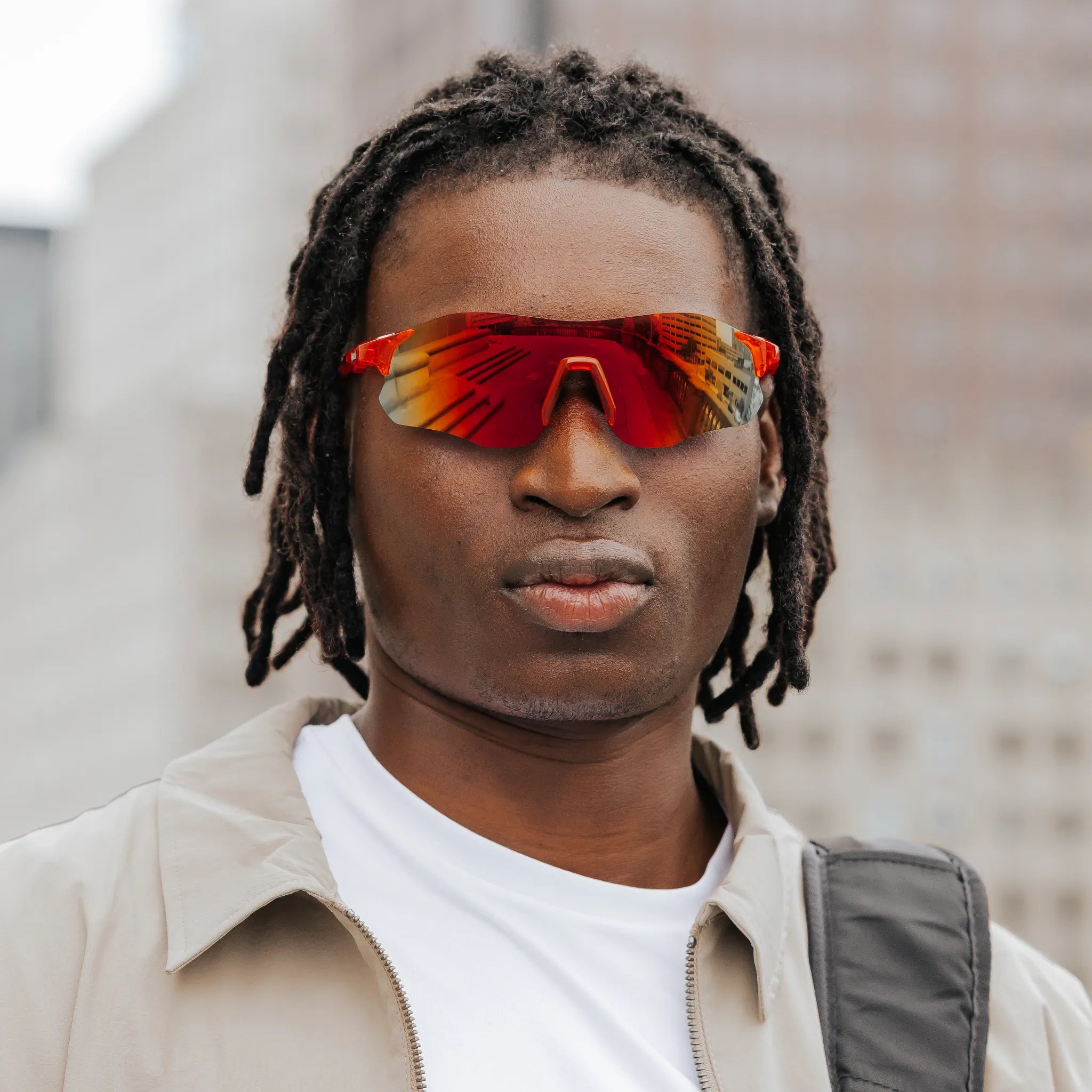 Front view of model wearing Edge Lava sunglasses with red mirrored wraparound lenses.