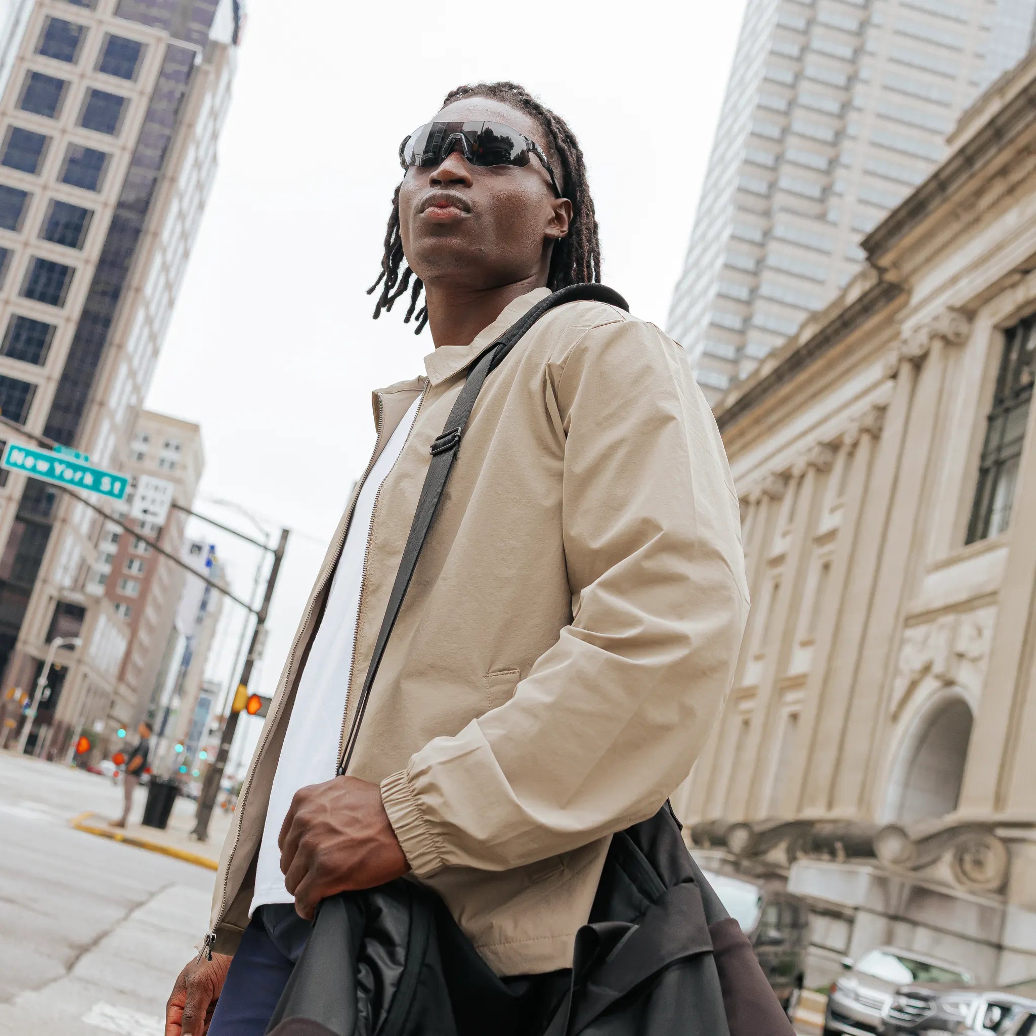 Model wearing Edge Shadow sunglasses in a city environment, full-body lifestyle shot.