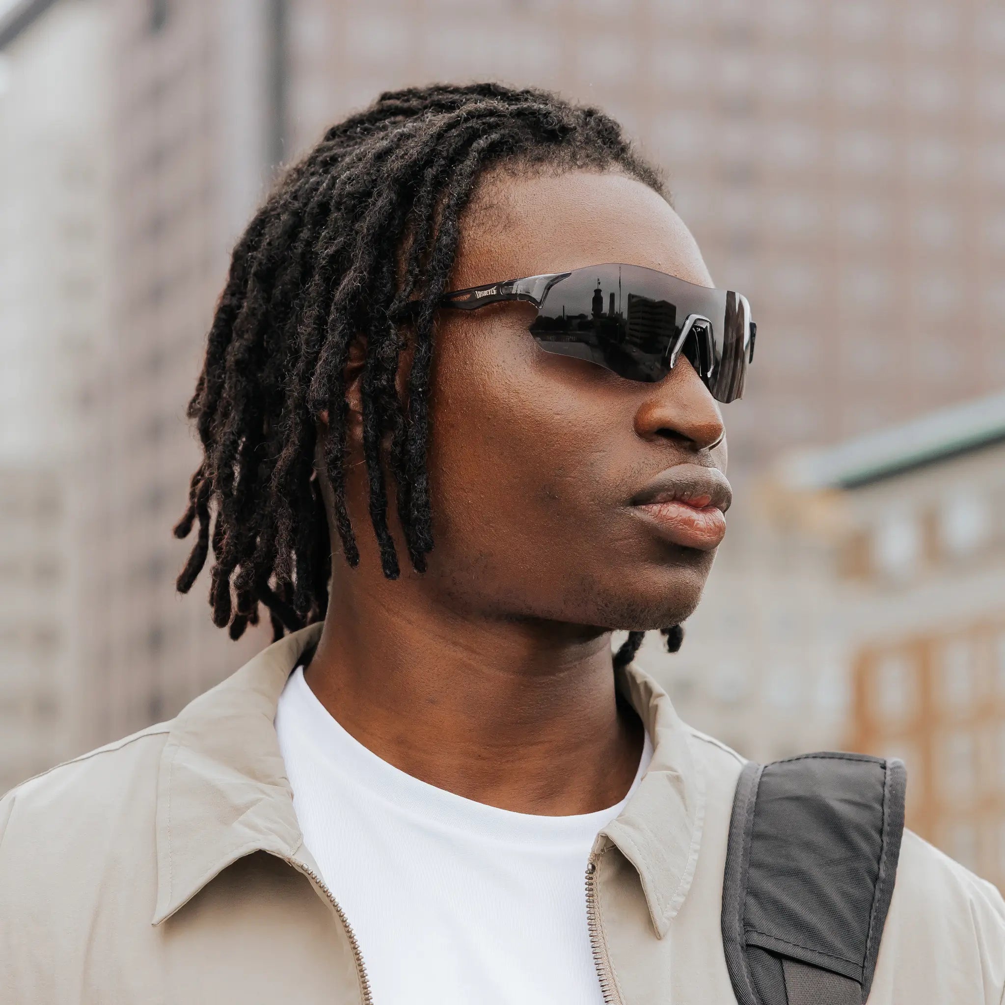 Side profile of model wearing Edge Shadow sunglasses with black wraparound lenses.