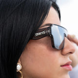 Close-up of a person wearing HADES sunglasses with 'LosReyes' branding.