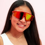 Girl wearing LosReyes Candy Collection Cream Red sunglasses featuring mirrored red lens and playful frame for kids’ active wear