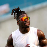 Tyreek Hill wearing LosReyes Cheetah Orange mirrored wraparound sunglasses while training with a football – high-performance sports sunglasses for men.