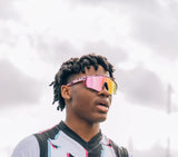 Stylish young man wearing LosReyes Cheetah Collection pink sunglasses under cloudy sky