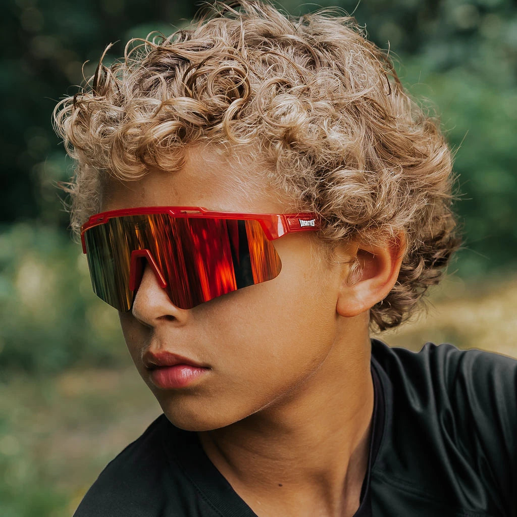 Youth wearing LosReyes Jurassic Series T-Rex red sunglasses outdoors
