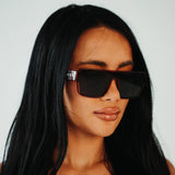 Lifestyle front view of LosReyes Omega Ares blackout sunglasses featuring angular wraparound design, deep black lenses, and premium tortoiseshell frame for bold urban fashion.