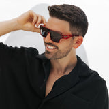 Man wearing red Ares Omega collection lifestyle sunglasses from LosReyes with a blurred white background