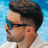 Man wearing LosReyes sunglasses pair Poseidon from Omega collection with a pool in the background