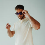 Lifestyle image of LosReyes Omega Zeus sunglasses featuring bold angular shield design, deep purple mirrored lenses, and black performance frame — ideal for high-impact sports, casual streetwear, and UV protection.