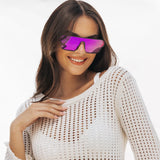 Woman wearing a white crochet top and purple LosReyes Omega Zeus sunglasses on a light gray background