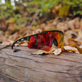 LosReyes Polarized Red sports sunglasses resting on a forest log, featuring UV400 shield protection, impact-ready TR90 durability, and pro-level polarized clarity for outdoor athletes.