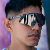 Lifestyle photo of LosReyes Prime Galaxy Moon wraparound sunglasses paired with modern streetwear, reflecting bold mirrored lenses and lightweight clear frames for active fashion.