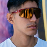 Lifestyle image of athlete wearing LosReyes Prime Galaxy Pluto red mirrored wraparound sunglasses, perfect for sun-intensive performance and street style.