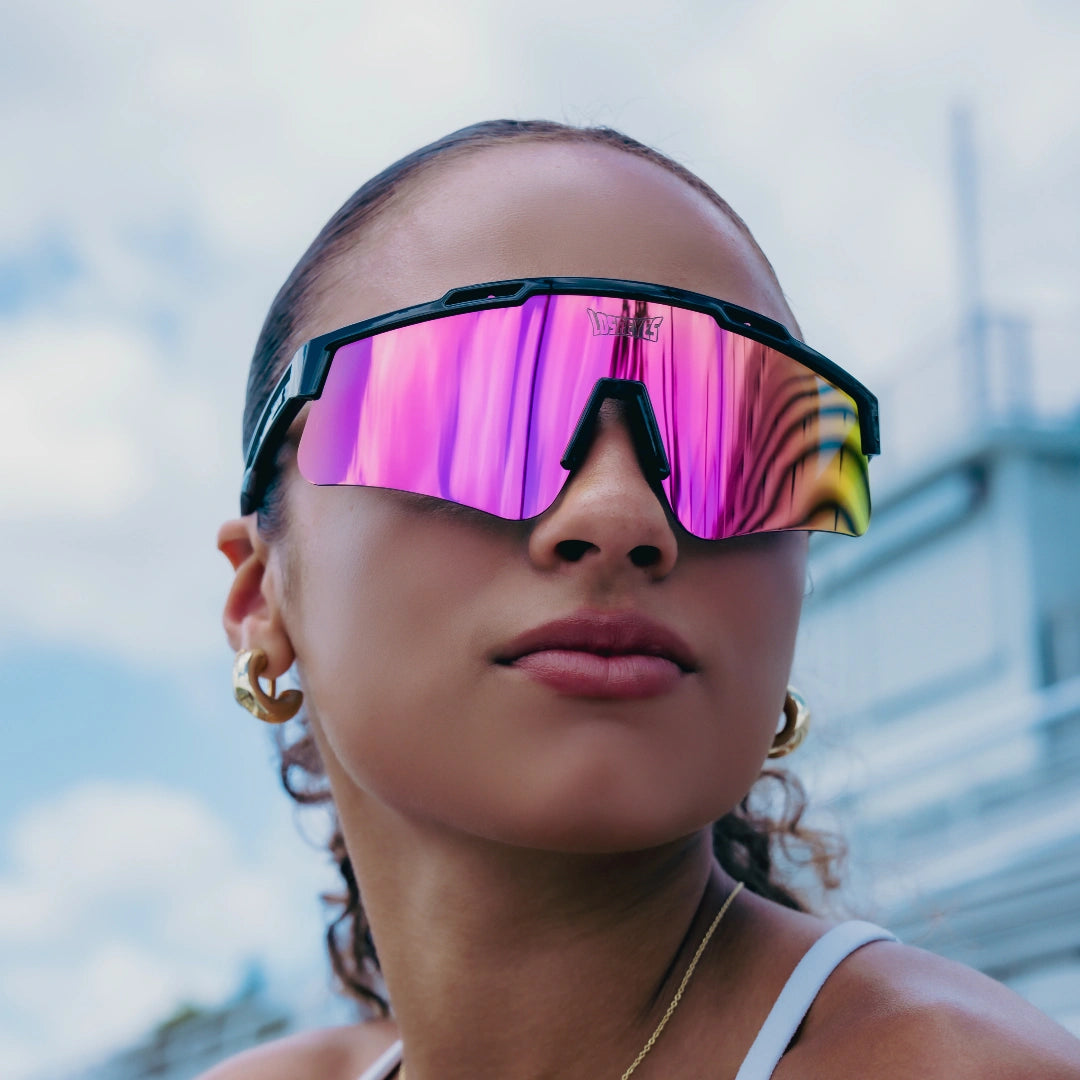 Female athlete wearing LosReyes Prime Polarized Pink mirrored sunglasses with wraparound performance frame and vivid pink shield lens, styled for elite-level training, competition, and everyday active fashion.