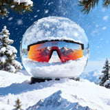 Snow globe with LosReyes polarized sunglasses reflecting mountains on a snowy background