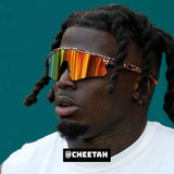 Side-angle lifestyle image of Tyreek Hill wearing LosReyes orange cheetah mirrored shield sports sunglasses with a wide lens wraparound design, styled for elite athletic performance