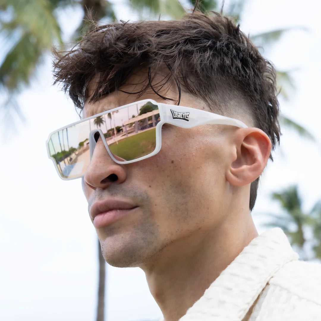 Person wearing reflective LosReyes lifestyle sunglasses with a blurred outdoor background