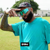 Odell Beckham Jr. wearing LosReyes Uranus Galaxy sunglasses and a turquoise shirt while posing at a football camp